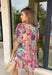Soft, flowy, and full of spring color, this short sleeve dress by Umgee is a total breath of fresh air. Featuring a watercolor-inspired abstract floral print in shades of pink, blue, green, purple, and off white, this dress feels light and dreamy for the season. Smocking along the top creates a flattering, comfortable fit, while the front tie detail, elastic sleeves, and tiered skirt add movement and charm. Fully lined and made from breathable tencel