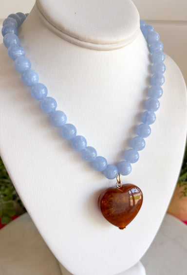 Fun, playful, and full of personality! This necklace features light blue beading paired with a brown heart pendant for the perfect touch of contrast. Lightweight and easy to style, this necklace looks just as cute worn on its own as it does layered with your favorite chains and beaded pieces. It’s the perfect finishing touch for adding a subtle pop of color to your everyday outfits.