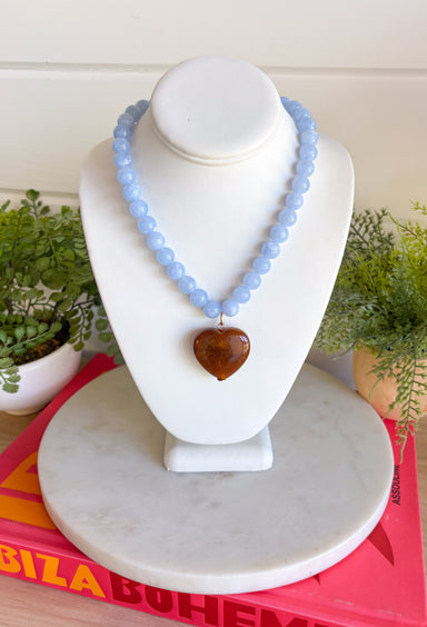 Fun, playful, and full of personality! This necklace features light blue beading paired with a brown heart pendant for the perfect touch of contrast. Lightweight and easy to style, this necklace looks just as cute worn on its own as it does layered with your favorite chains and beaded pieces. It’s the perfect finishing touch for adding a subtle pop of color to your everyday outfits.