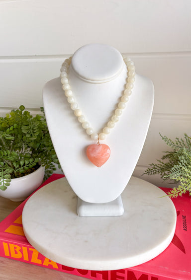 Sweet, playful, and full of charm! This white beaded necklace features a light pink heart pendant that adds the perfect soft pop of color. The combination of crisp white beads and the blush heart charm creates a fresh, feminine look that’s easy to style for everyday wear. Lightweight and easy to layer, this necklace looks just as cute worn on its own as it does stacked with your favorite gold or beaded pieces. It’s a simple way to add a little love and personality to any outfit.