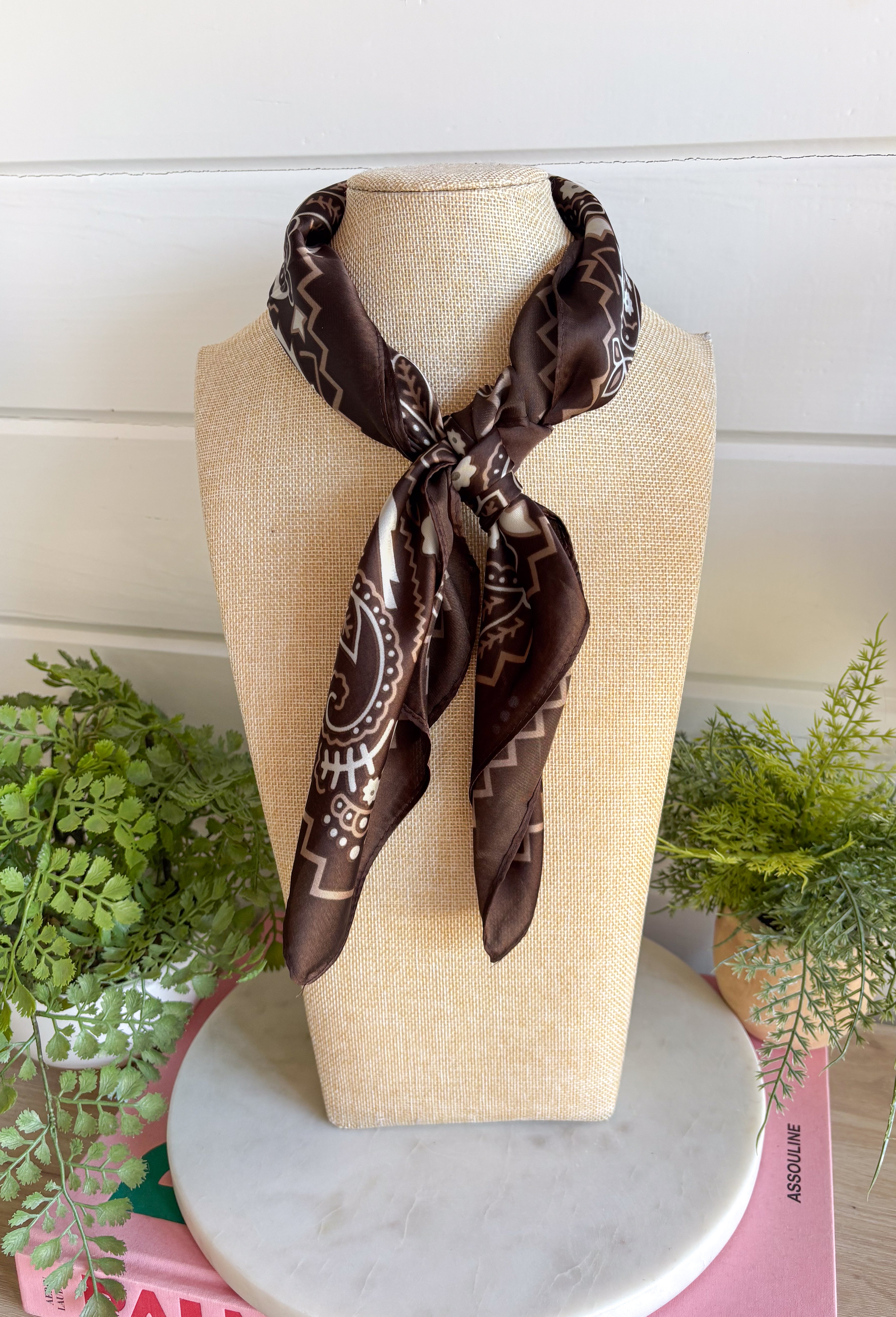 Add an easy western-inspired touch to your outfit with this brown bandana neck scarf. The rich brown color makes it a versatile accessory for fall while the soft material keeps it comfortable enough to wear all day long. Tie it around your neck for a classic bandana look, wear it as a headband, or knot it onto your favorite handbag for a fun pop of personality. From gameday and concerts to weekend plans and fall outings, there are plenty of ways to make this scarf your own.