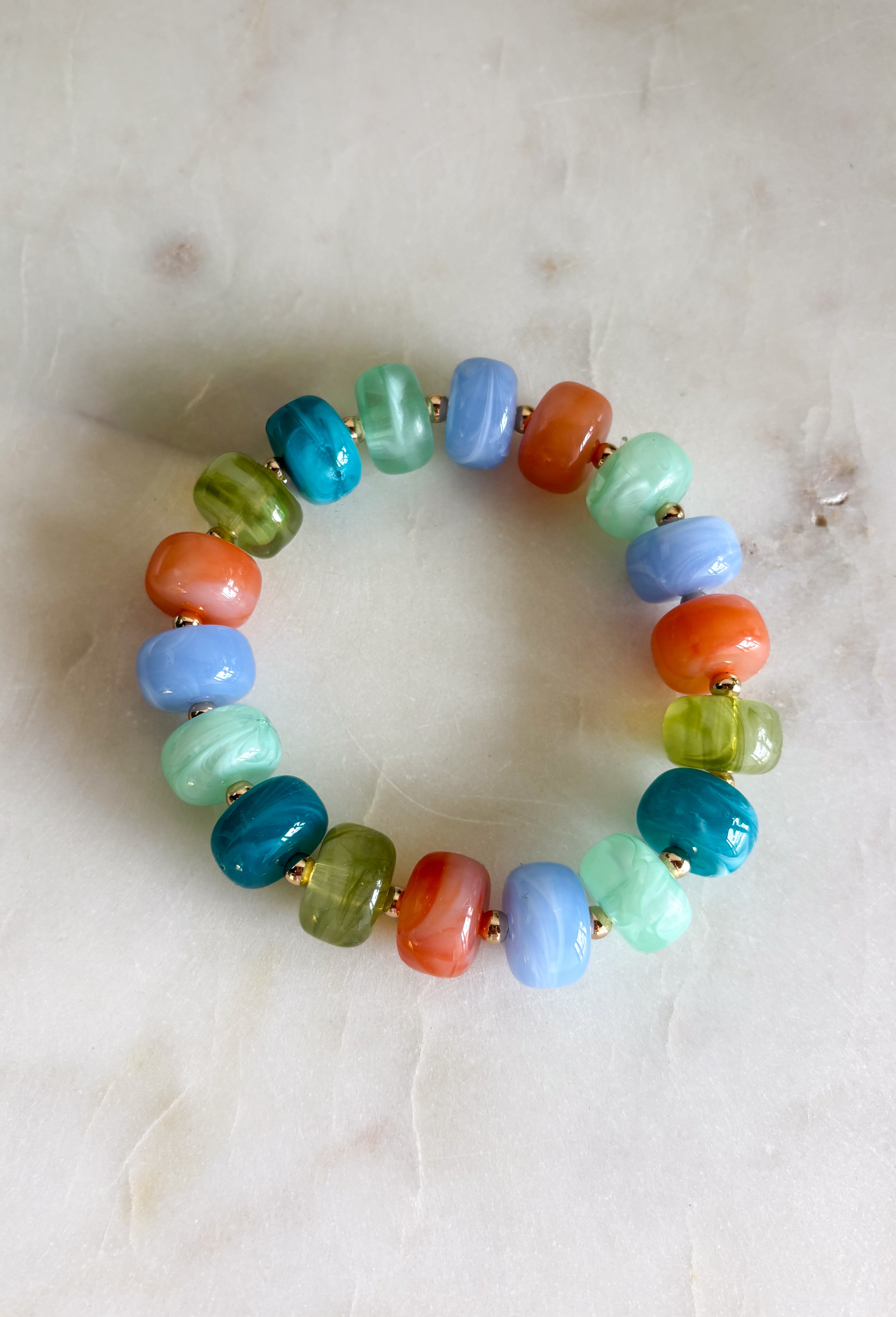 Add a playful pop of color to your everyday stack with this beaded bracelet from Garden Party. Shades of blue, orange, and green create a bright mix, while small gold beads in between add just the right touch of shine. The pull-on design makes it easy to slip on and go, whether you’re wearing it solo or mixing it with your favorite bracelets. It’s a fun little accessory for bringing extra color and personality to even the simplest outfit.