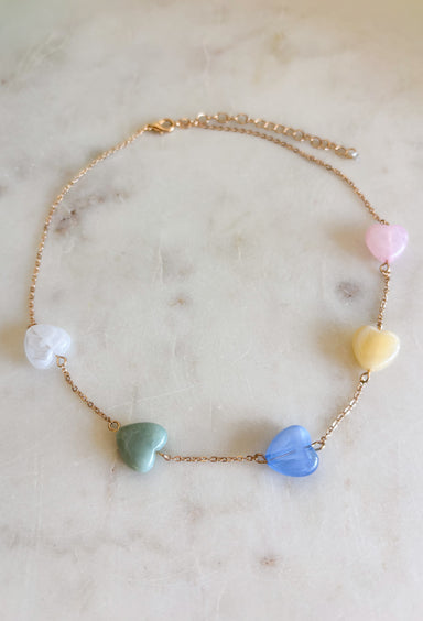 Girl, this dainty gold chain necklace with pastel heart charms is giving all the sweet spring vibes! It’s the perfect everyday necklace to add a soft pop of color while still keeping things simple and chic. Lightweight and easy to layer, this cutie pairs effortlessly with your favorite tees, dresses, or even a cozy knit for those breezy spring mornings. Whether you're heading to brunch, carpool, or date night, this piece adds just the right touch of charm.
