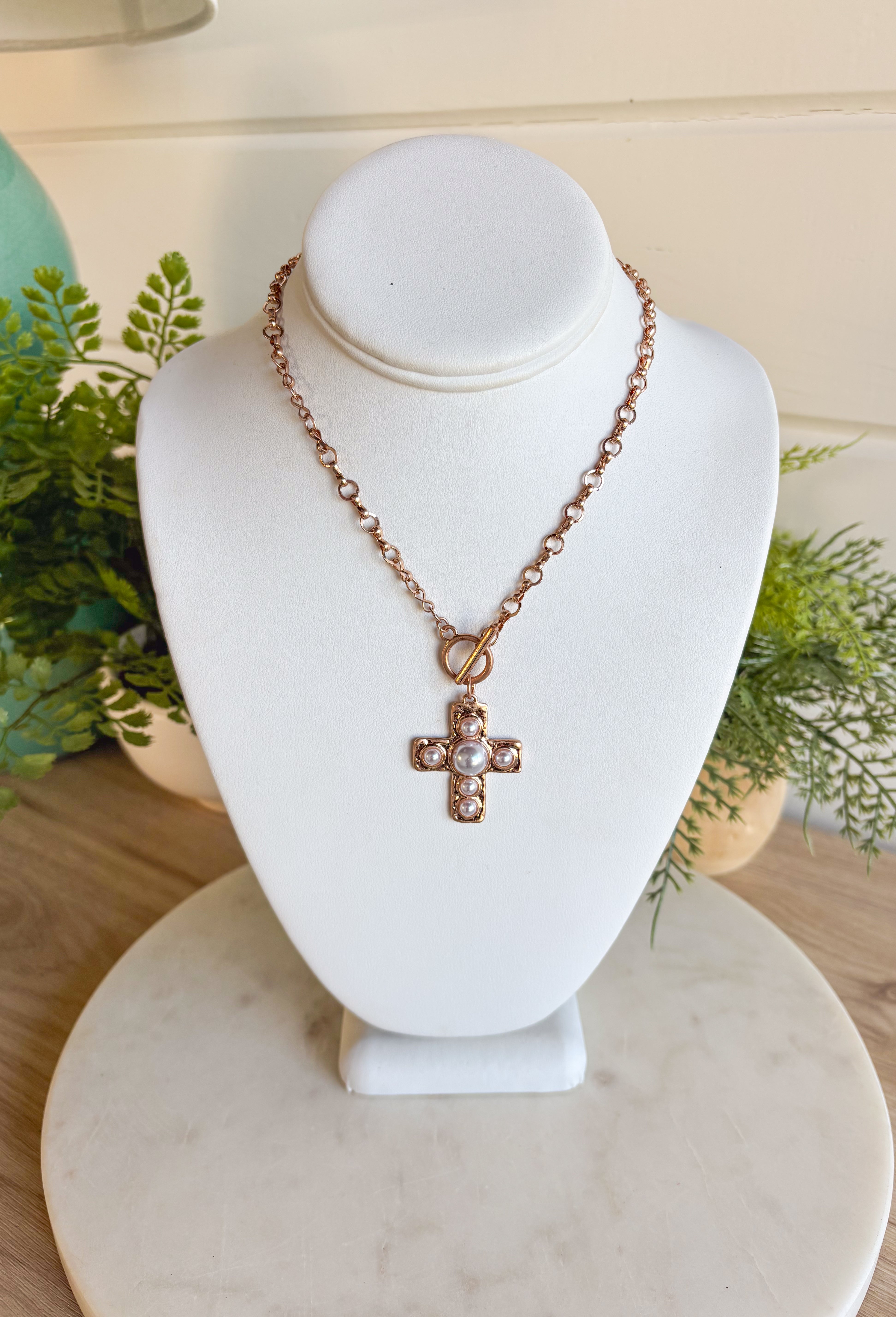 Classic with a modern edge, this matte gold chain necklace is designed with a pearl cross pendant and toggle clasp for a timeless finish. Measuring approximately 15" with a 3" extender, it’s the perfect length for layering or wearing on its own. Whether styled with casual looks or dressier outfits, this piece adds a touch of elegance that works for any occasion.