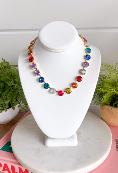 Add a meaningful touch of color to your jewelry collection with this beautiful cross necklace. Featuring a strand of colorful rhinestone crystals in shades of red, blue, green, pink, and gold, this eye-catching piece is finished with a matching cross pendant for the perfect blend of faith and style. The vibrant colors and delicate gold accents make it a standout accessory that's easy to wear for both everyday outfits and special occasions.