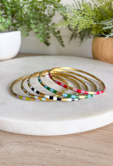 Give ‘em the RAZZLE DAZZLE with the iconic 5 bangle stack that started it all! This playful stack is brass with resin inlay and has beautiful neutrals paired with bright pops of red, pink, turquoise &amp; green while anchored by classic black and white. Stack them high with style.&nbsp;