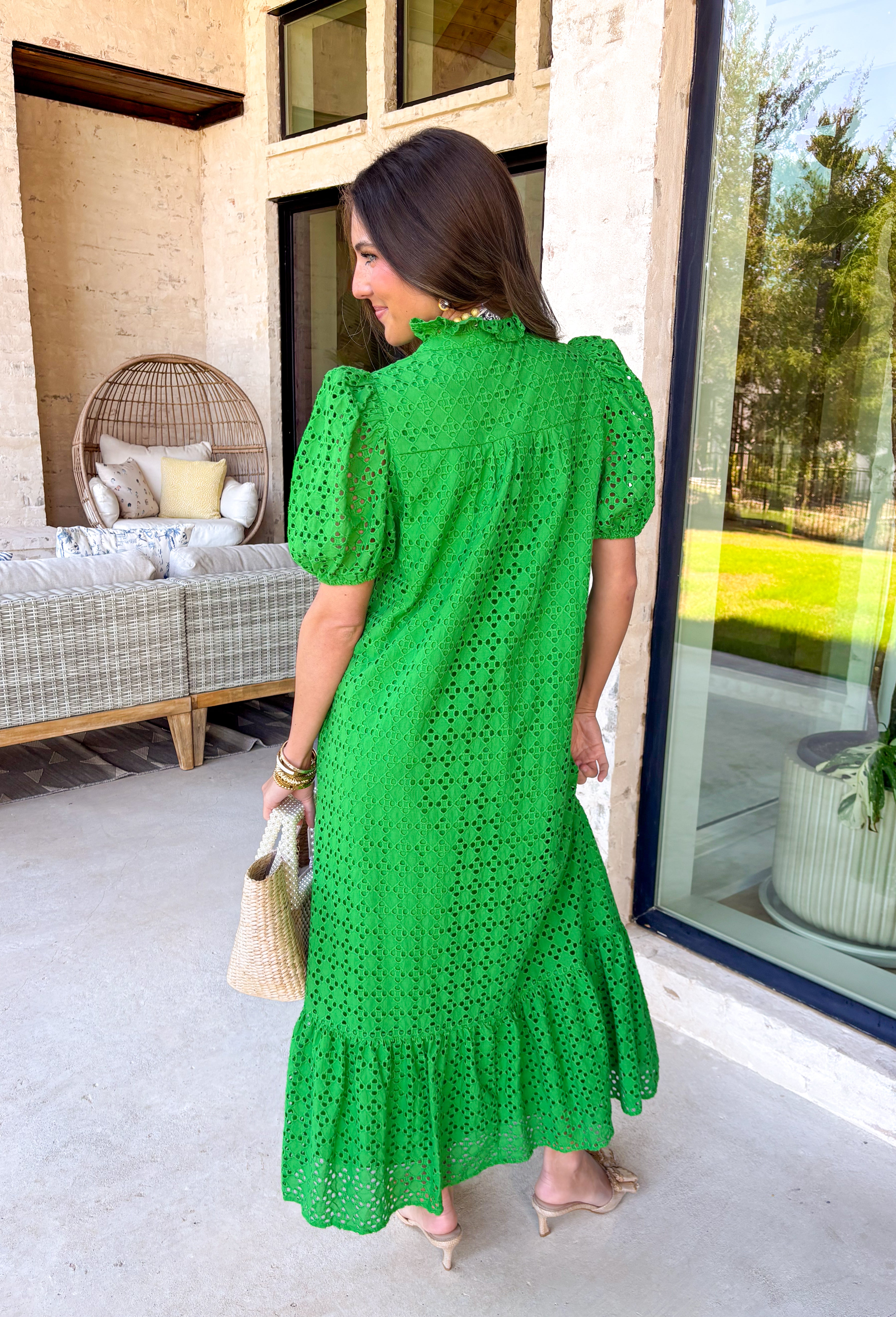 Soft, romantic, and perfect for spring, this green eyelet midi dress by Entro is a true seasonal favorite. The eyelet fabric adds beautiful texture while keeping the look light and airy, and the ruffled mock neck brings a sweet, vintage-inspired touch. Short puff sleeves and a ruffle hem give it an effortless flow, while the button-front closure adds classic charm. 