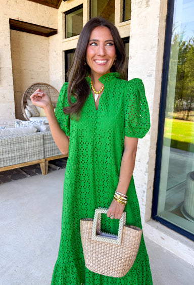 Soft, romantic, and perfect for spring, this green eyelet midi dress by Entro is a true seasonal favorite. The eyelet fabric adds beautiful texture while keeping the look light and airy, and the ruffled mock neck brings a sweet, vintage-inspired touch. Short puff sleeves and a ruffle hem give it an effortless flow, while the button-front closure adds classic charm. 