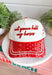 Bring a little western charm and plenty of personality to your everyday style with this fun trucker hat. Featuring a neutral front paired with a bold red bandana print bill, this standout accessory is embroidered with "Not Gonna Hold My Horses" across the front in vibrant red stitching. The side is finished with "Half Past Yee-Haw" embroidery, while a red embroidered horseshoe on the back adds the perfect finishing touch. 