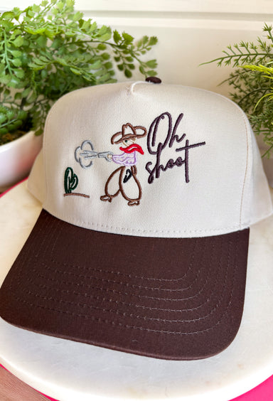 This trucker hat brings the perfect mix of western charm and playful personality! Featuring an embroidered cowboy, cactus, and the phrase "Oh Shoot," it's a fun conversation starter that adds a little humor to any casual outfit. The neutral crown and brown bill make it easy to pair with just about everything, while the adjustable fit keeps it comfortable for all-day wear. 