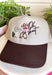 This trucker hat brings the perfect mix of western charm and playful personality! Featuring an embroidered cowboy, cactus, and the phrase "Oh Shoot," it's a fun conversation starter that adds a little humor to any casual outfit. The neutral crown and brown bill make it easy to pair with just about everything, while the adjustable fit keeps it comfortable for all-day wear. 