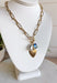 A little bit classic, a little bit playful — this gold paperclip chain necklace is the perfect piece to wear all year long. Designed with a mix of charming details like a textured heart, a pearl accent, and a touch of blue rhinestone sparkle, it adds just the right amount of personality to any look. Finished with a toggle clasp for easy wear, it’s made to shine from everyday outfits to special occasions.