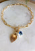 A little bit classic, a little bit playful — this gold paperclip chain necklace is the perfect piece to wear all year long. Designed with a mix of charming details like a textured heart, a pearl accent, and a touch of blue rhinestone sparkle, it adds just the right amount of personality to any look. Finished with a toggle clasp for easy wear, it’s made to shine from everyday outfits to special occasions.