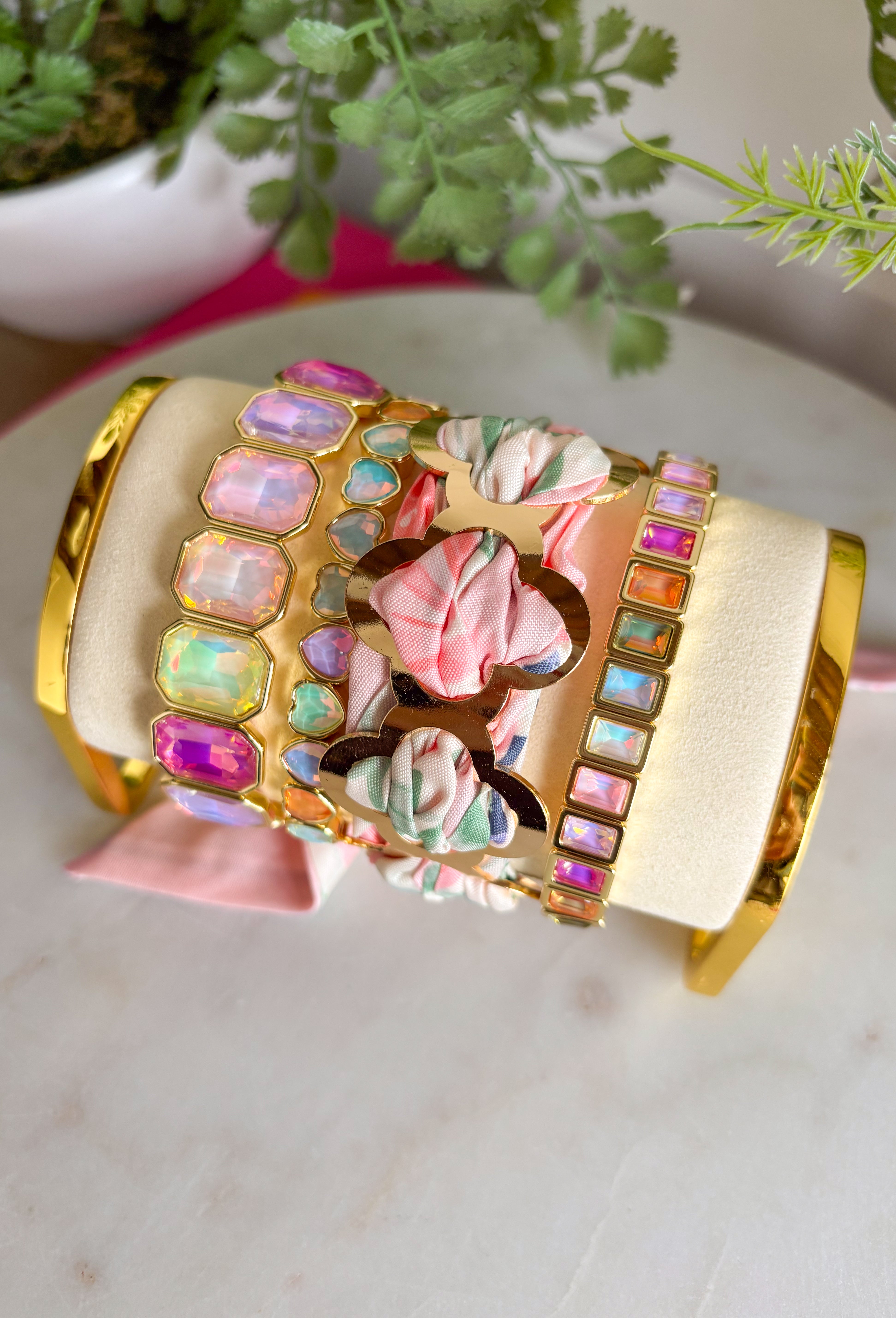 A bold statement with a feminine twist! This fabric wrapped chain link bracelet features oversized gold chain links wrapped in silky scarf-style fabric for a playful pop of color. The soft blend of pink, off white, and green creates a fresh, cheerful look that instantly brightens any outfit. The mix of polished gold and colorful fabric gives this piece a trendy yet effortless feel, making it the perfect accessory for dressing up a simple outfit or adding personality to your everyday style.