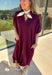 Effortless and versatile, this burgundy midi dress is an easy favorite for fall. Designed with a band collar v-neckline and elasticated short sleeves, it offers both structure and comfort. Side pockets keep it practical, while the soft, stretchy fabric blend makes it perfect for all-day wear. You'll find yourself reaching for this dress all season long!