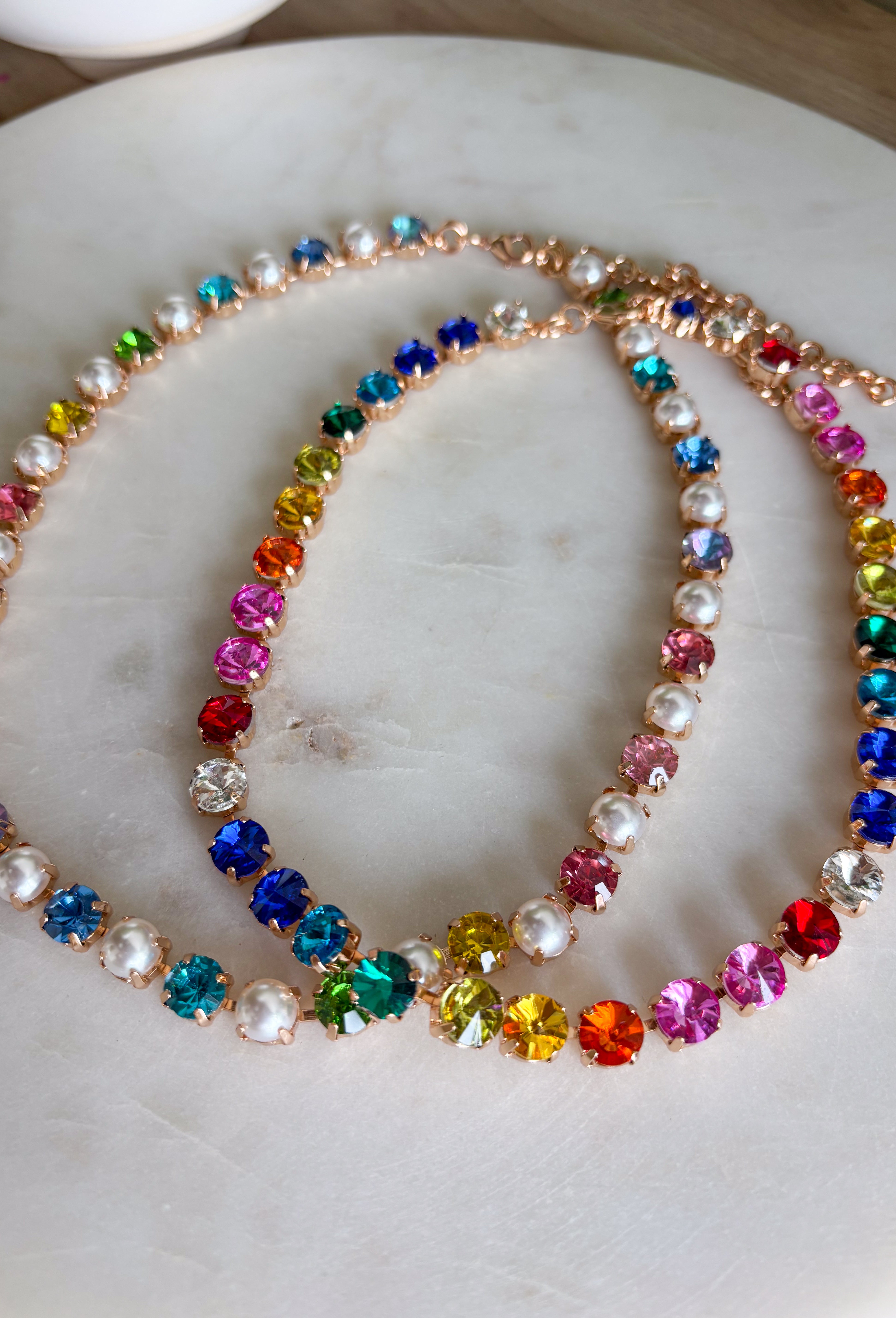 This vibrant rainbow gemstone necklace is pure spring joy in accessory form. Featuring faceted crystal stones in bold, playful colors, each gem is set in a warm gold setting that adds just the right touch of polish. The mix of colors makes it an instant outfit-lifter—perfect for adding personality to everyday looks or finishing off a fun spring outfit. Wear it solo as a statement or layer it with your favorite gold chains for an easy, colorful moment.