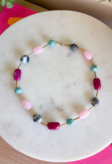 Add the perfect finishing touch to your outfit with this beautifully detailed beaded necklace! Featuring pink, turquoise, marble, and raspberry beads separated by shimmering gold accents, this timeless piece brings just the right amount of color and elegance to your jewelry collection. The 18K gold-dipped finish gives it a polished look that's easy to wear from everyday outings to special occasions, making it a versatile accessory you'll reach for season after season.
