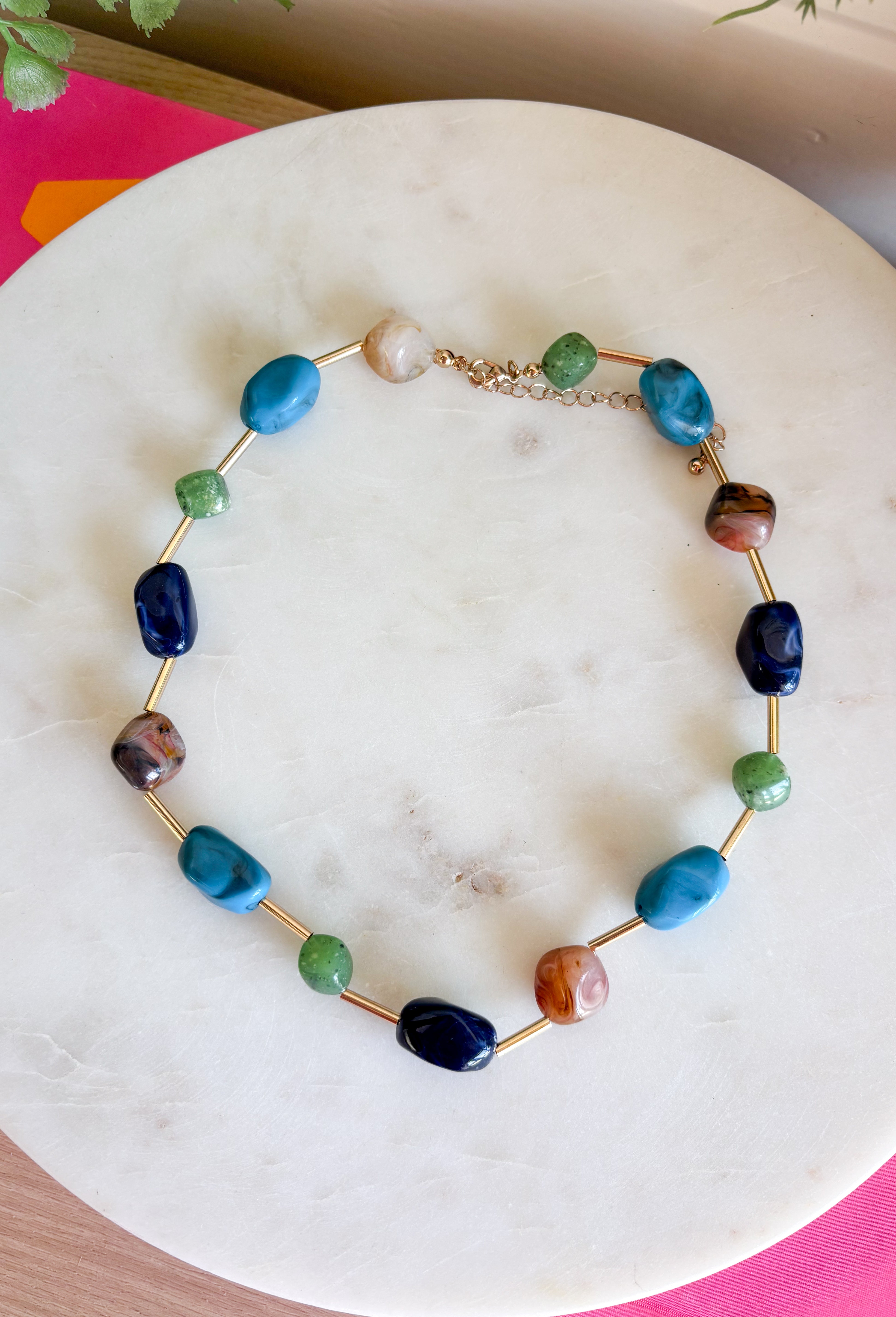 Add the perfect finishing touch to your outfit with this beautifully detailed beaded necklace! Featuring turquoise, green, brown, and navy beads separated by shimmering gold accents, this timeless piece brings just the right amount of color and elegance to your jewelry collection. The 18K gold-dipped finish gives it a polished look that's easy to wear from everyday outings to special occasions, making it a versatile accessory you'll reach for season after season.