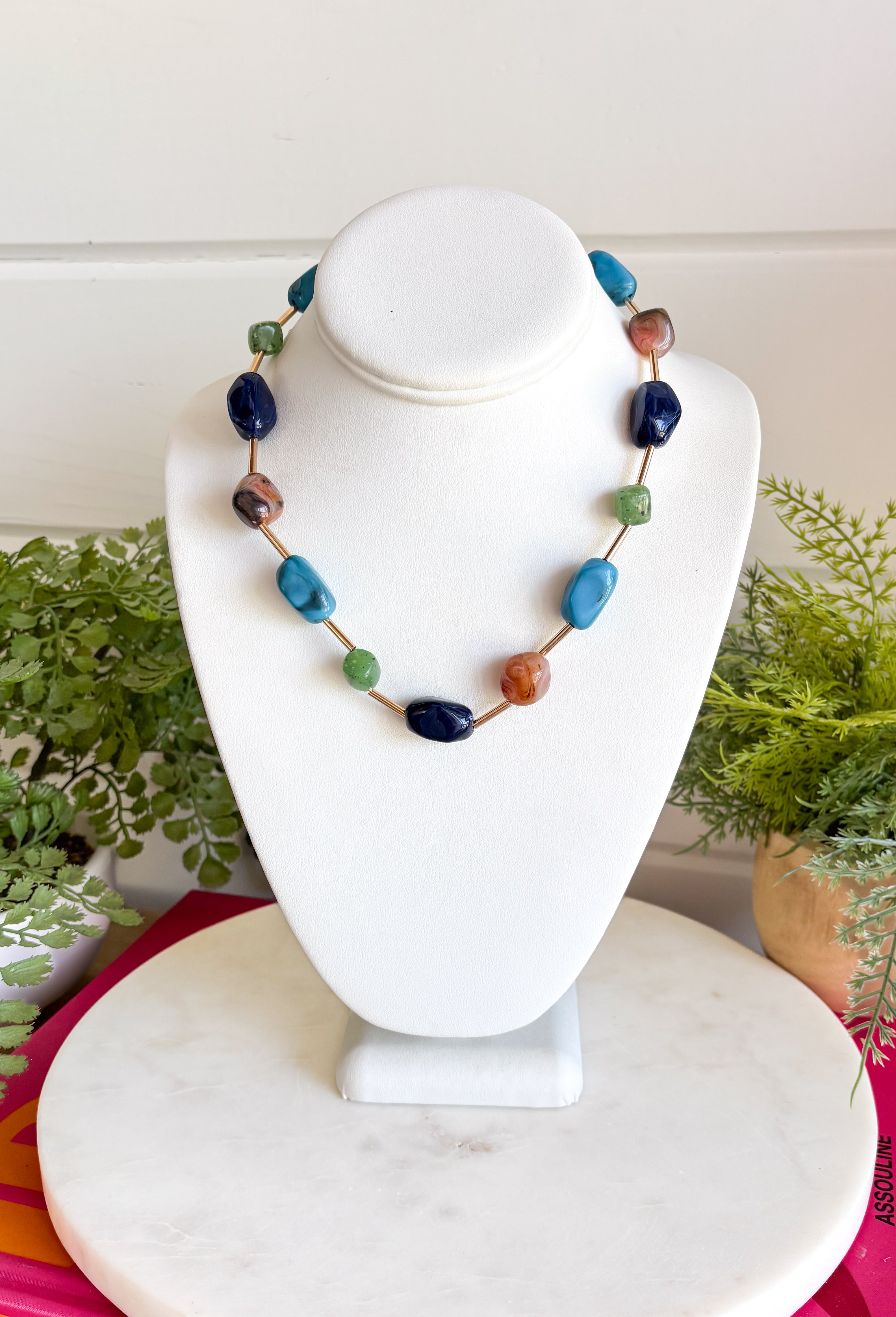 Add the perfect finishing touch to your outfit with this beautifully detailed beaded necklace! Featuring turquoise, green, brown, and navy beads separated by shimmering gold accents, this timeless piece brings just the right amount of color and elegance to your jewelry collection. The 18K gold-dipped finish gives it a polished look that's easy to wear from everyday outings to special occasions, making it a versatile accessory you'll reach for season after season.
