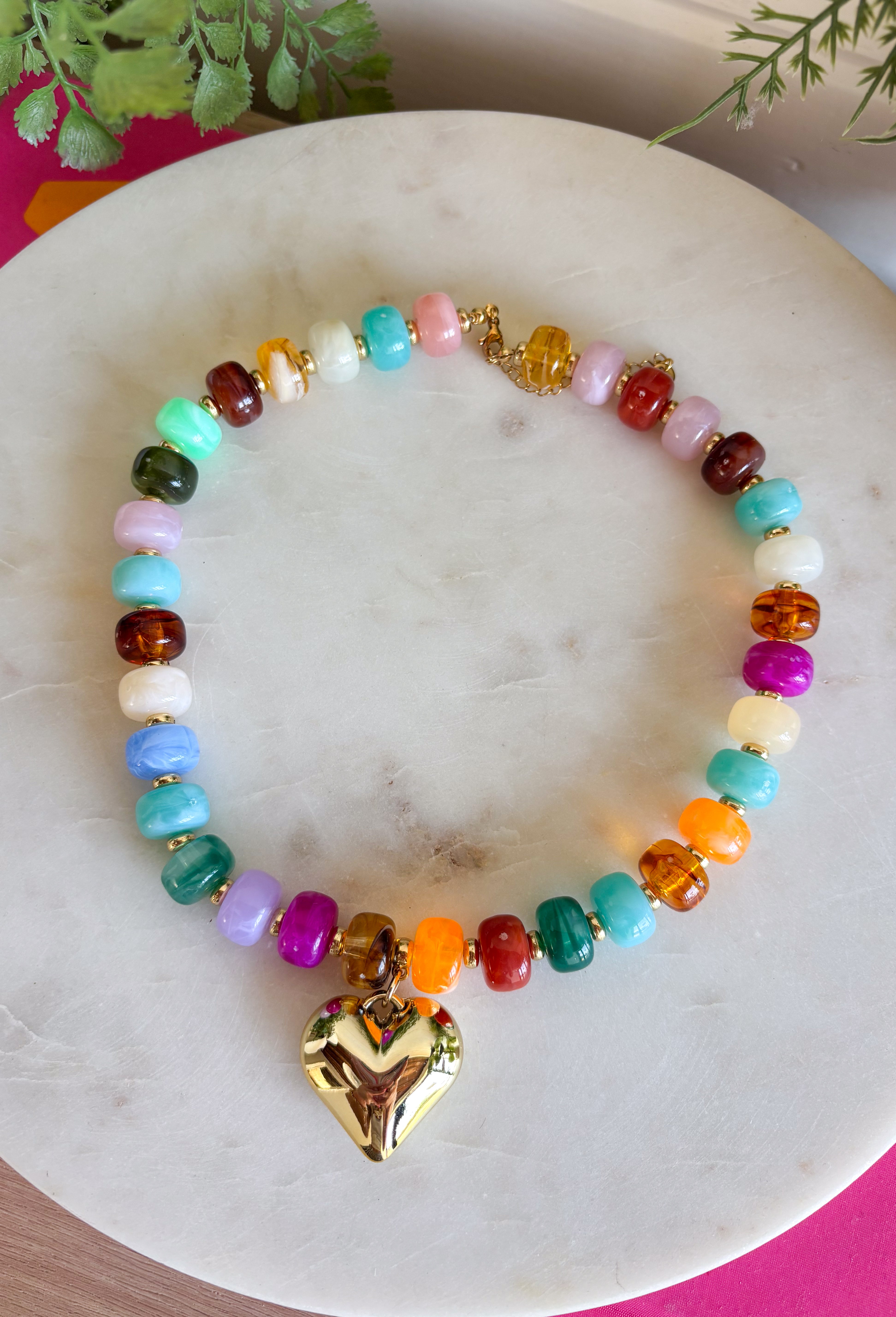 Add a meaningful finishing touch to your favorite outfits with this beautifully crafted beaded necklace. Featuring rich shades of autumn beads accented with delicate gold beads throughout, this timeless piece is finished with a gold heart charm for the perfect blend of classic style and everyday elegance. Whether worn on its own or layered with your favorite chains, this versatile necklace adds just the right amount of charm to everything from cozy sweaters to dresses and blouses all season long.