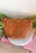 Everyone's favorite bag is back in a bold new design! The Studded Westlyn Bum Bag from Pretty Simple features the same hands-free style you love, now updated with eye-catching gold stud detailing for the perfect touch of edge. Crafted from soft vegan leather, this versatile bag can be worn as a belt bag or crossbody, making it the perfect companion for busy days, concerts, travel, shopping, and everyday adventures. Stylish, functional, and easy to wear, it's sure to become your new go-to accessory.