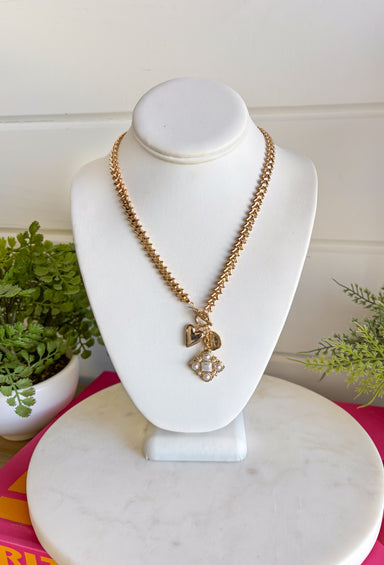 This chunky gold textured chain necklace is the statement piece your spring outfits have been waiting for! With its bold chain and mixed charm design featuring pearl detailing, it brings the perfect mix of trendy and timeless. The textured finish adds dimension, while the pearls soften the look with a classic touch. Perfect for brunch, events, or everyday wear when you want to feel a little extra. Go ahead—this one deserves a spot in your jewelry lineup!