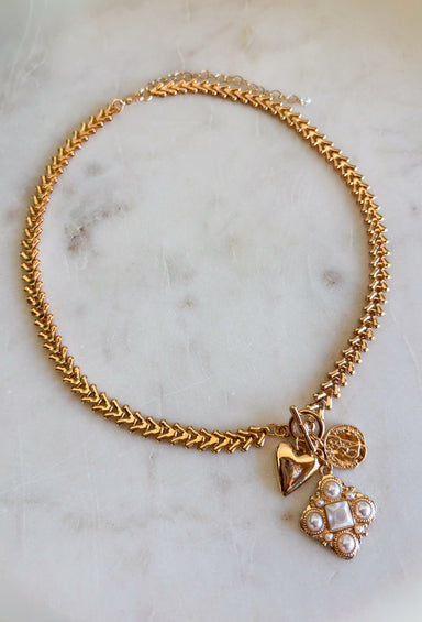 This chunky gold textured chain necklace is the statement piece your spring outfits have been waiting for! With its bold chain and mixed charm design featuring pearl detailing, it brings the perfect mix of trendy and timeless. The textured finish adds dimension, while the pearls soften the look with a classic touch. Perfect for brunch, events, or everyday wear when you want to feel a little extra. Go ahead—this one deserves a spot in your jewelry lineup!