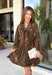 Feminine, chic, and full of seasonal charm, this floral dress is the perfect piece for all your favorite fall occasions. Featuring a classic brown backdrop with a vibrant colorful floral print, this dress offers a timeless silhouette with eye-catching details. The flattering v-neckline is accented by a beautiful scarf tie that adds a polished, sophisticated touch, while the self-tie waist creates a customizable fit you'll love. 