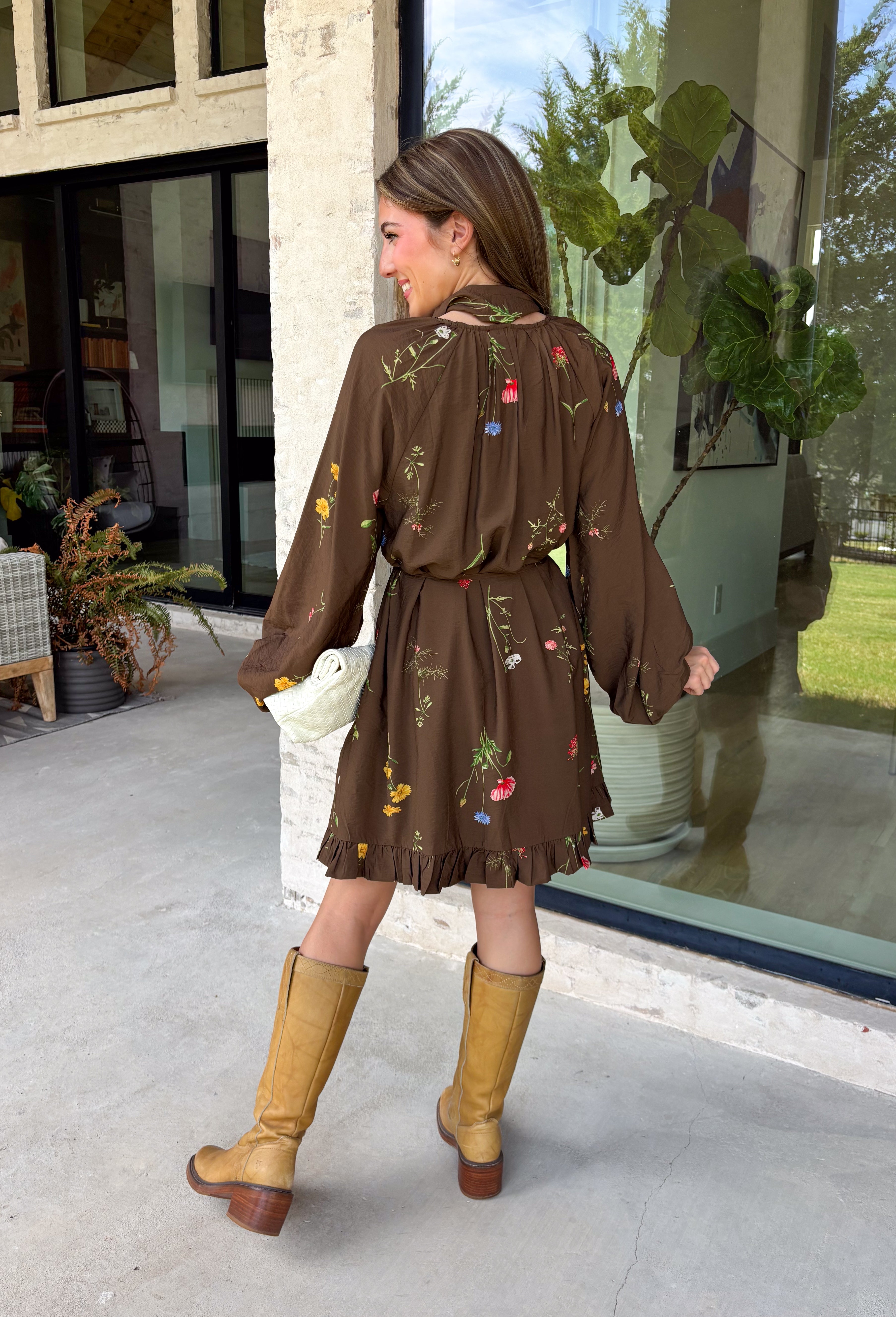Feminine, chic, and full of seasonal charm, this floral dress is the perfect piece for all your favorite fall occasions. Featuring a classic brown backdrop with a vibrant colorful floral print, this dress offers a timeless silhouette with eye-catching details. The flattering v-neckline is accented by a beautiful scarf tie that adds a polished, sophisticated touch, while the self-tie waist creates a customizable fit you'll love. 