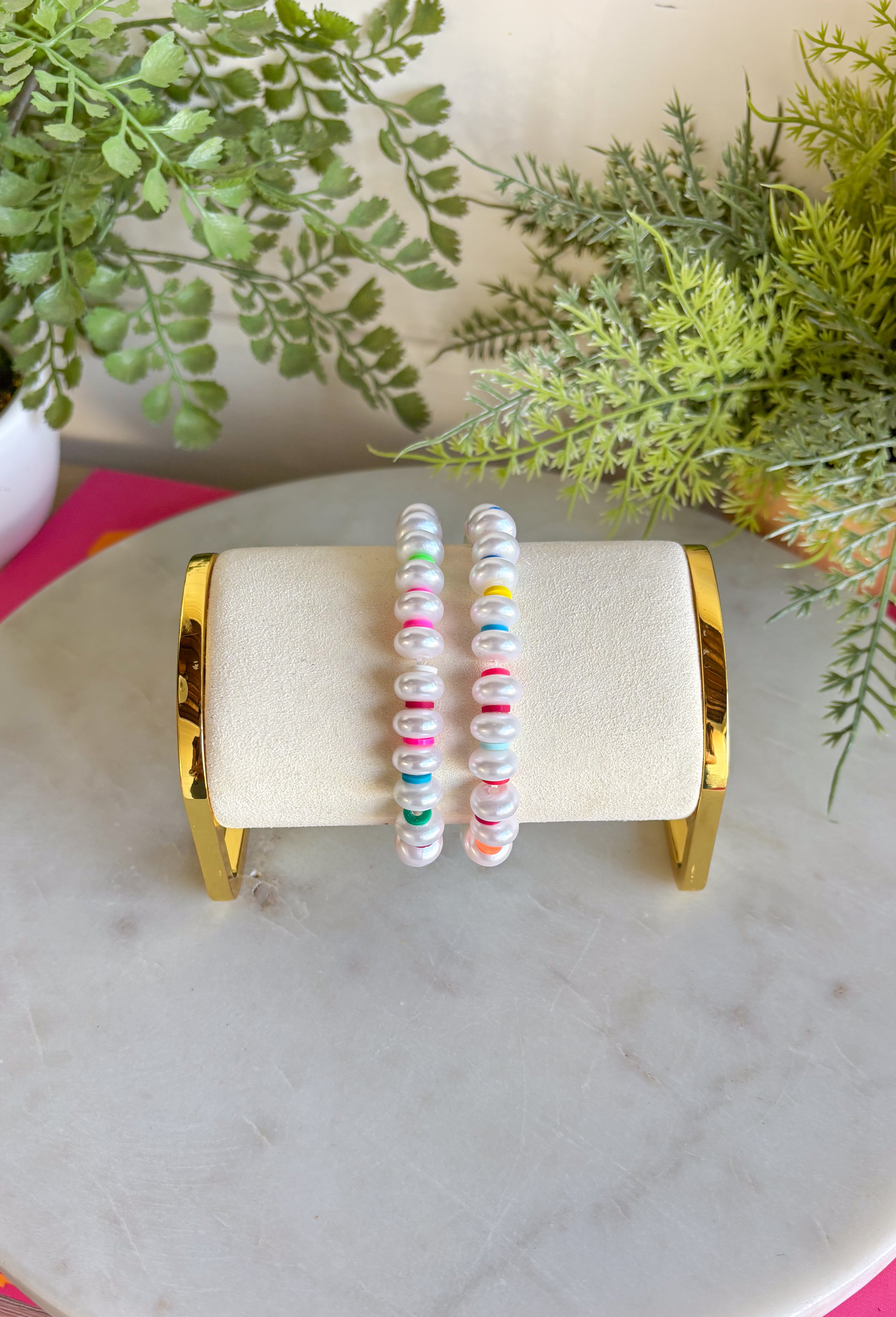 Bright, playful, and made for sunny days! This set of two pearl bracelets is the perfect pop of color for summer. Classic pearls are mixed with vibrant disc beads in pink, green, blue, orange, and red for a fun, feel-good stack that instantly livens up any outfit. Wear them together for a bold statement or mix and match with your favorite everyday bracelets for a layered look. Lightweight and easy to style, these are the kind of accessories you’ll reach for all season long.