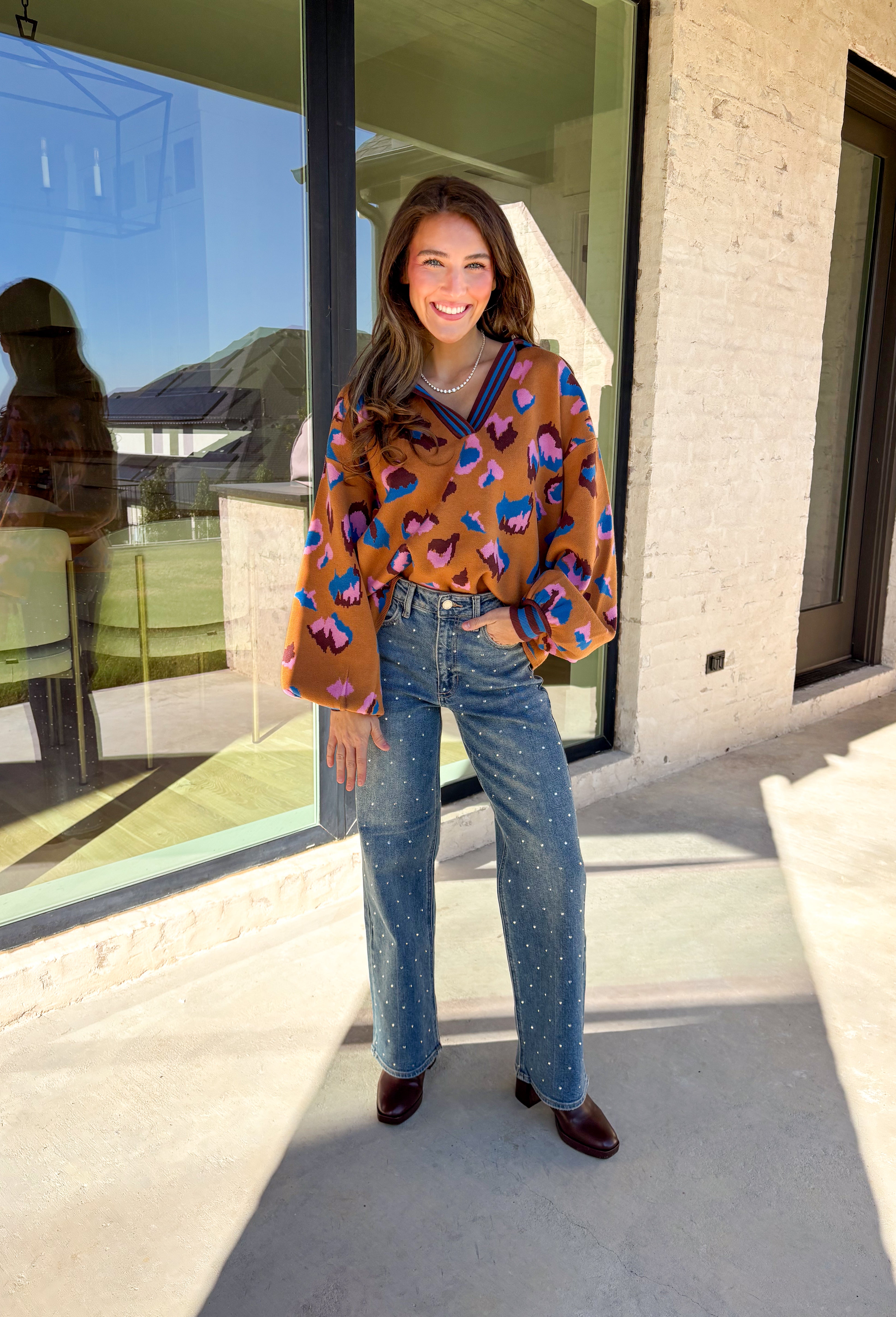 Brighten up your winter wardrobe with this bold camel sweater by Fate, featuring an eye-catching leopard print in shades of brown, pink, and blue. The striped collar and neckline add a fun, sporty touch while the soft knit keeps things cozy and comfortable for chilly days. It’s the perfect statement sweater for adding color and personality to your cold-weather lineup.