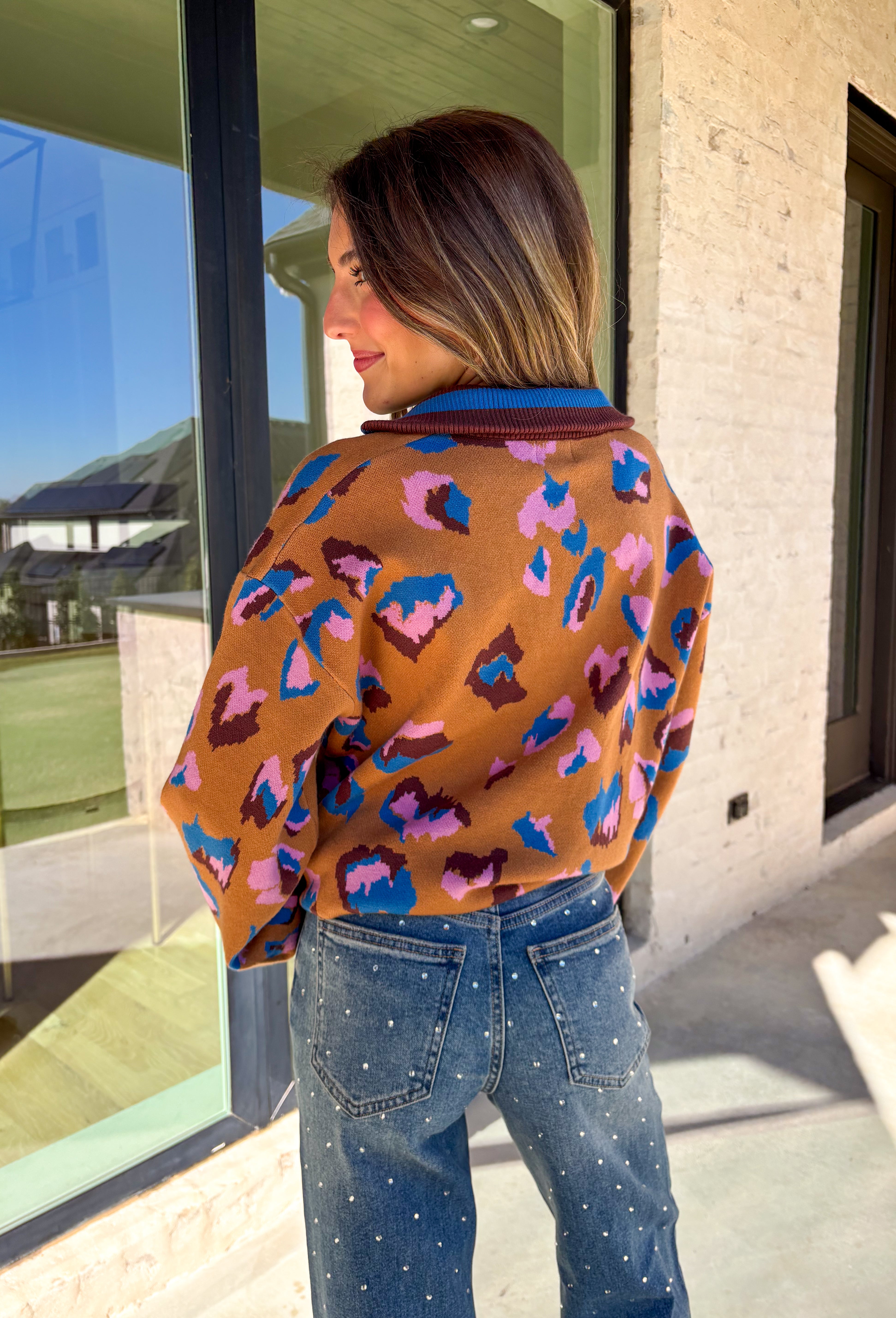 Brighten up your winter wardrobe with this bold camel sweater by Fate, featuring an eye-catching leopard print in shades of brown, pink, and blue. The striped collar and neckline add a fun, sporty touch while the soft knit keeps things cozy and comfortable for chilly days. It’s the perfect statement sweater for adding color and personality to your cold-weather lineup.