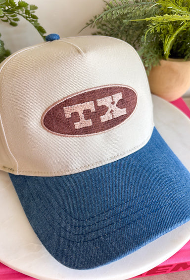 Simple, timeless, and full of Texas pride! This neutral trucker hat is the perfect everyday accessory for anyone who loves the Lone Star State. Featuring a brown embroidered patch outlined in tan with a bold "TX" design, it pairs effortlessly with everything from graphic tees to cozy sweatshirts. The denim bill adds a laid-back touch, while the adjustable back ensures a comfortable fit for all-day wear.