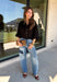 Every wardrobe needs a timeless black blouse, and this versatile top from Entro is one you'll reach for again and again. Designed with a flattering v-neckline and button-front closure, this effortlessly polished piece transitions seamlessly from workdays to weekends. The ¾ roll-tab sleeves offer versatile styling, while the elasticized smocked back hem creates a comfortable fit with a modern touch. 