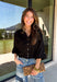 Every wardrobe needs a timeless black blouse, and this versatile top from Entro is one you'll reach for again and again. Designed with a flattering v-neckline and button-front closure, this effortlessly polished piece transitions seamlessly from workdays to weekends. The ¾ roll-tab sleeves offer versatile styling, while the elasticized smocked back hem creates a comfortable fit with a modern touch. 