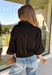 Every wardrobe needs a timeless black blouse, and this versatile top from Entro is one you'll reach for again and again. Designed with a flattering v-neckline and button-front closure, this effortlessly polished piece transitions seamlessly from workdays to weekends. The ¾ roll-tab sleeves offer versatile styling, while the elasticized smocked back hem creates a comfortable fit with a modern touch. 