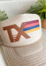Top off your fall outfits with this timeless trucker hat featuring a classic brown "TX" graphic with a beautiful fall-inspired print. The neutral tan crown makes it easy to pair with all your favorite seasonal looks, while the rich autumn shades add the perfect pop of color. Designed with a breathable mesh back and an adjustable fit, this hat is made for everything from pumpkin patch visits and football weekends to running errands around town. 