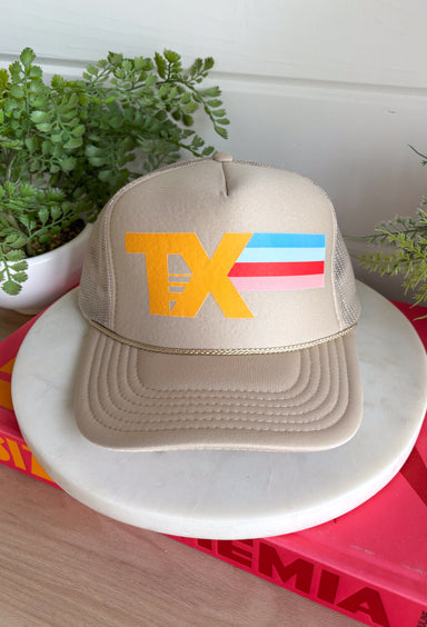 This tan trucker hat with a vibrant “TX” graphic is the perfect way to top off your summer look! The neutral base keeps it easy to style, while the bold pop of blue, red, and pink adds just the right amount of fun. Designed with a breathable mesh backing and adjustable fit, it’s made for sunny days on the go—whether you’re at the ball field, running errands, or heading out for a casual day. It’s equal parts practical and cute, which makes it a must-have for summer. Add it to your cart and wear it on repeat!