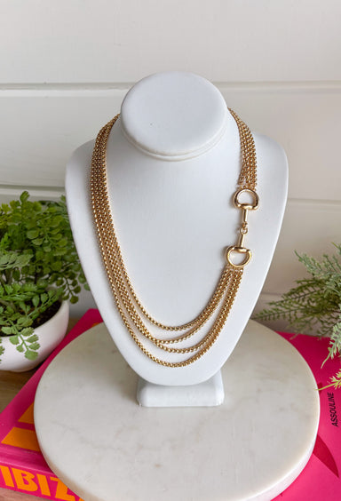 This gold layered chain necklace with a horse bit detail is the perfect blend of trendy and timeless for summer styling! The layered look gives you that effortlessly styled feel without the extra work, while the horse bit detail adds a classic, elevated touch. At 19.5" in length, it sits perfectly to make a statement on its own or pair with shorter chains for a stacked look. Whether you're dressing up a simple tank or adding polish to a breezy dress, this piece pulls everything together. 
