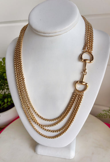 This gold layered chain necklace with a horse bit detail is the perfect blend of trendy and timeless for summer styling! The layered look gives you that effortlessly styled feel without the extra work, while the horse bit detail adds a classic, elevated touch. At 19.5" in length, it sits perfectly to make a statement on its own or pair with shorter chains for a stacked look. Whether you're dressing up a simple tank or adding polish to a breezy dress, this piece pulls everything together. 