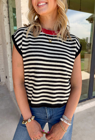 Timeless stripes get a fun seasonal update in this cozy short sleeve sweater. Featuring classic black and white stripes with a bold red contrast neckline, this knit is the perfect blend of classic and playful. The soft, cozy fabric makes it ideal for crisp fall mornings and cool evenings, while the short sleeves make layering effortless under jackets, and blazers. 