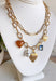 Turn any outfit into a statement with this chunky gold layered chain necklace. The double-layer design creates an effortless stacked look, while the second chain features an assortment of charming details — textured gold hearts, a pearl accent, a blue rhinestone, and a tan heart charm. It’s the perfect mix of bold and feminine, making it a go-to accessory for all season long.