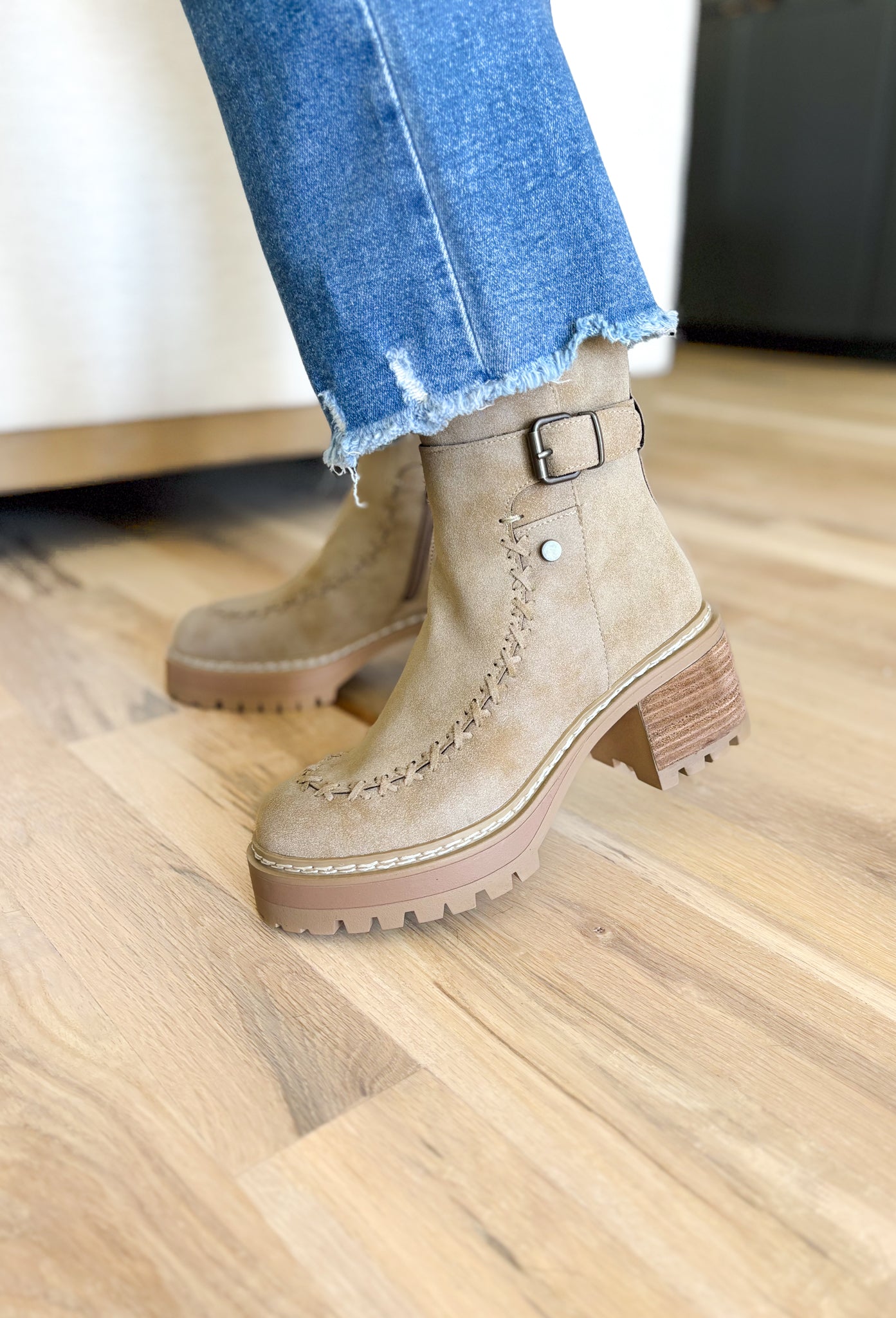 Toula Lug Sole Booties, taupe lug sole bootie with whip stitching around the whole boot, buckle on the top of the boot, wood and gum lug sole 