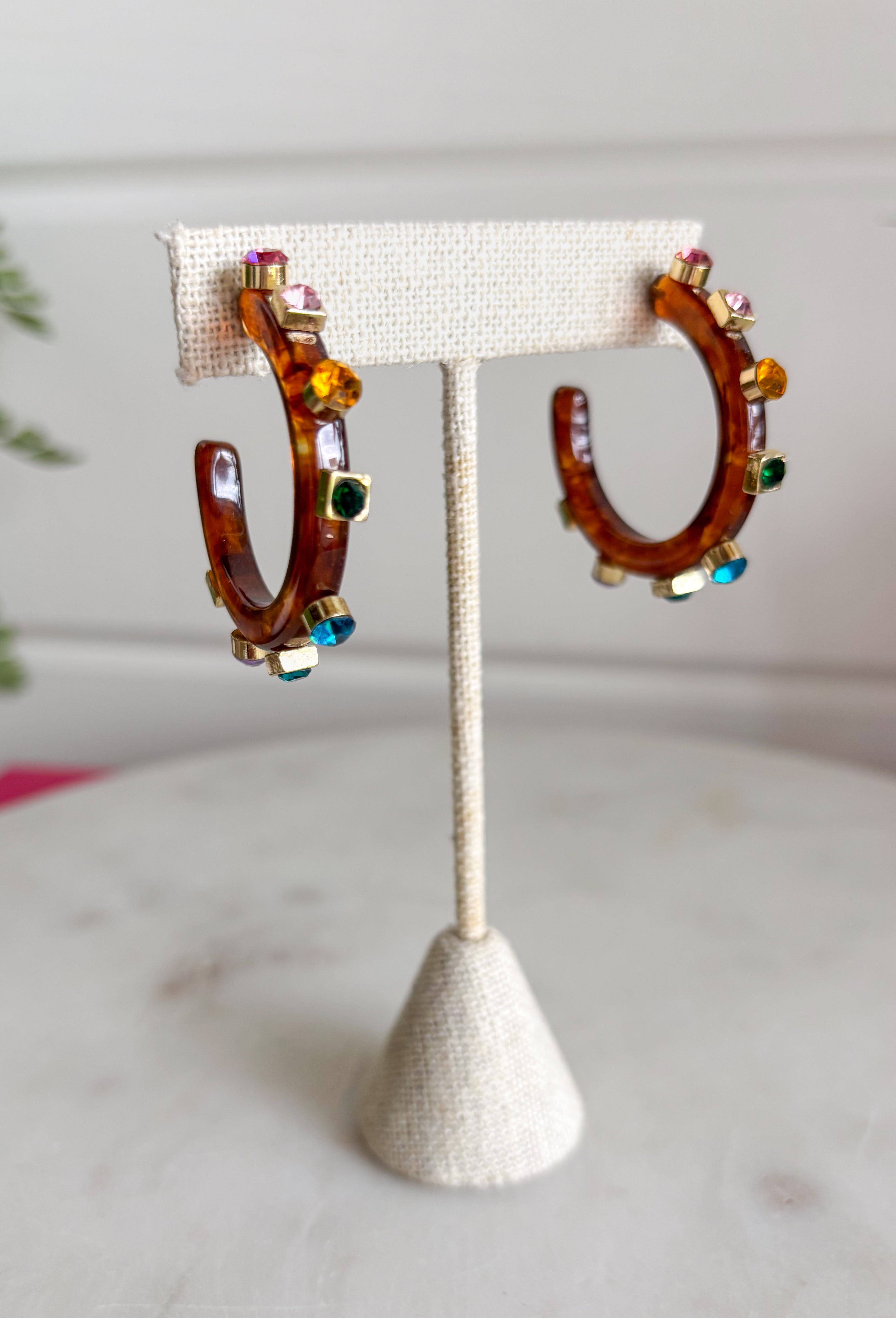 A little sparkle and a lot of personality! These glossy tortoise earrings are the perfect mix of classic and colorful. Designed with vibrant jewel-tone crystals, they add the prettiest pop of color while the tortoise finish keeps the look timeless and easy to style. Lightweight and fun to wear, these earrings instantly elevate any outfit—from casual daytime looks to dressier evenings out. The bold color and shine make them an effortless statement piece you'll reach for again and again.