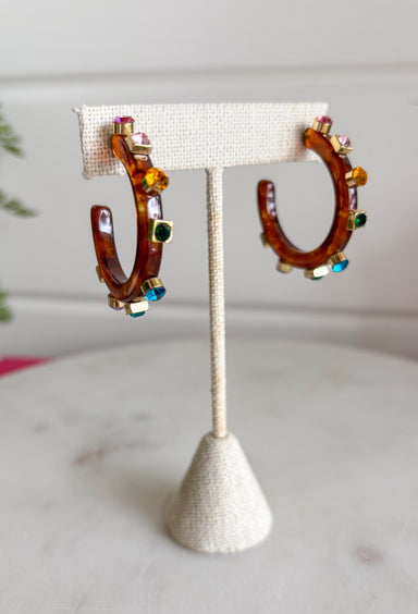 A little sparkle and a lot of personality! These glossy tortoise earrings are the perfect mix of classic and colorful. Designed with vibrant jewel-tone crystals, they add the prettiest pop of color while the tortoise finish keeps the look timeless and easy to style. Lightweight and fun to wear, these earrings instantly elevate any outfit—from casual daytime looks to dressier evenings out. The bold color and shine make them an effortless statement piece you'll reach for again and again.