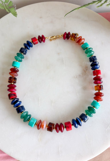 Turn up the color with this bold statement necklace from Treasure Jewels. An electric mix of turquoise, cobalt blue, emerald green, amber, and red beads creates a rich jewel-tone palette that instantly brings an outfit to life. A mix of bead shapes, sizes, and textures gives the necklace even more dimension and makes every color stand out. It’s the perfect piece for adding personality to a simple sweater, dress, or blouse when your outfit needs that one finishing touch.