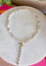 Classic pearls meet modern elegance in this stunning lariat necklace! Featuring lustrous pearls and a chic gold toggle closure, this timeless piece is finished with a sparkling rhinestone accent that adds just the right amount of shimmer. Whether you're dressing up for a holiday celebration, wedding, date night, or simply elevating your everyday style, this handcrafted necklace brings effortless sophistication to any outfit.