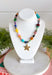 Color, texture, and a little golden shine come together in this playful necklace from Treasure Jewels. A dazzling mix of yellow, pink, blue, green, orange, gold, and spotted beads gives it a collected, one-of-a-kind feel, while the variety of shapes and textures makes every detail worth a closer look. A gold star pendant finishes the design with a fun statement at the center. Whether you’re brightening up a simple sweater or adding extra personality to a layered look, this necklace is made to stand out.