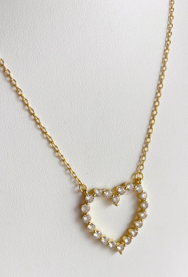 A sweet little sparkle you’ll reach for again and again! This delicate gold necklace features an open heart pendant adorned with shimmering crystal details that catch the light beautifully. The simple yet meaningful design makes it a timeless piece that adds a touch of shine to any outfit. Set on a fine gold chain with an adjustable length, it’s perfect for wearing on its own or layering with your favorite necklaces. 