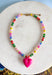 Bright, playful, and full of personality! This colorful beaded necklace is the perfect piece to add a little happiness to your look. Featuring a mix of vibrant beads and a bold hot pink pendant charm, it brings a fun pop of color that instantly livens up any outfit.&nbsp;The adjustable chain makes it easy to style at different lengths, whether worn on its own or layered with other favorites. Cheerful and eye-catching, this necklace is a simple way to add a little joy to your everyday style.